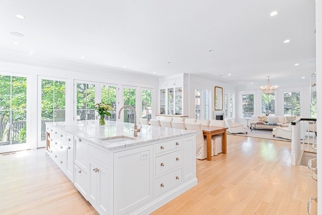 The open kitchen and living area looking toward the back windows and green tree line